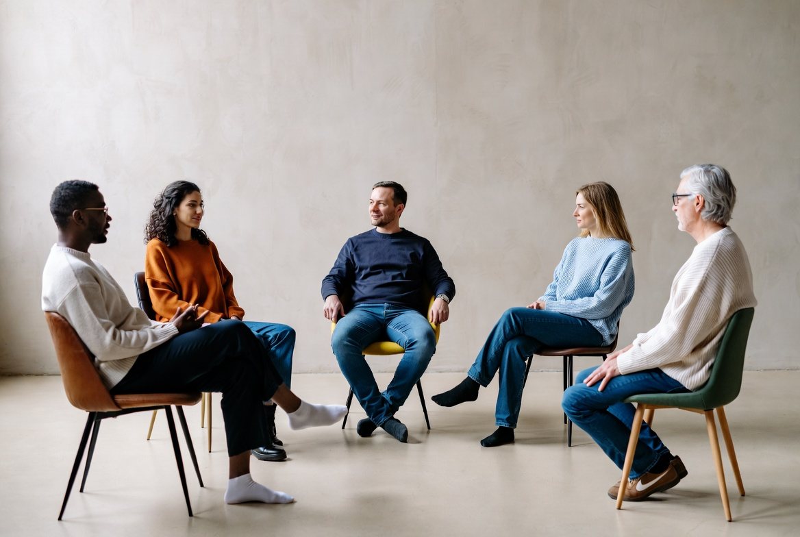 A small circle of people in a calm, facilitated session